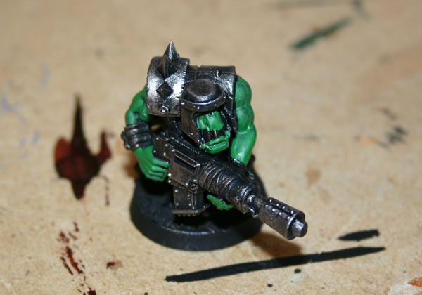 Once I have drybrushed the metal parts I use a dark green base for the Ork skin. 